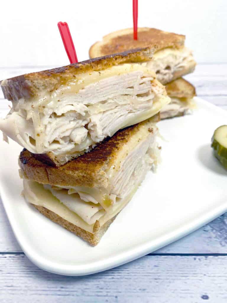 grilled turkey reuben sandwich on white plate