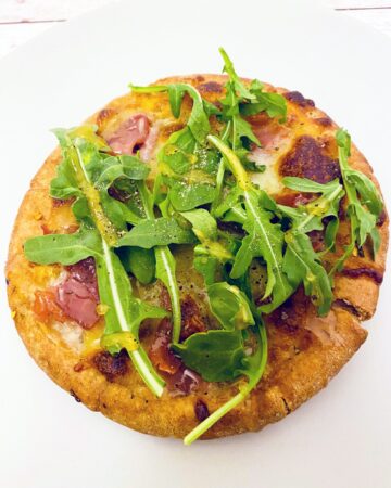 Prosciutto and Arugula are the toppings for this personal sized pizza made on a pita bread