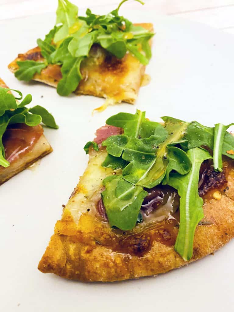 Prosciutto and Arugula are the toppings for this personal sized pizza made on a pita bread