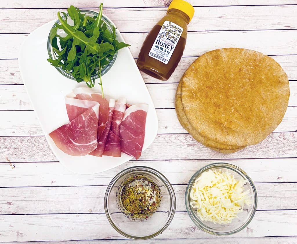 Prosciutto and Arugula are the toppings for this personal sized pizza made on a pita bread