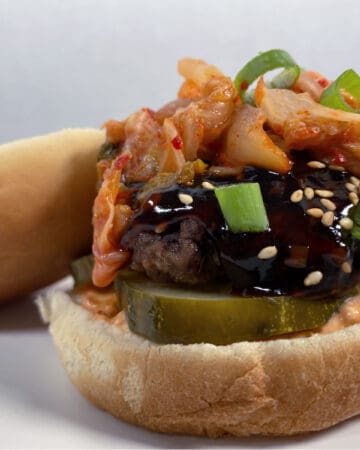 open faced beef burger covered in korean bbq sauce and topped with kimchi
