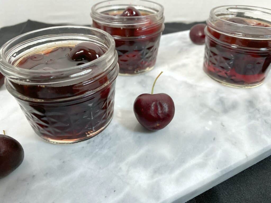 mason jars of cherries soaked in bourbon for cocktails