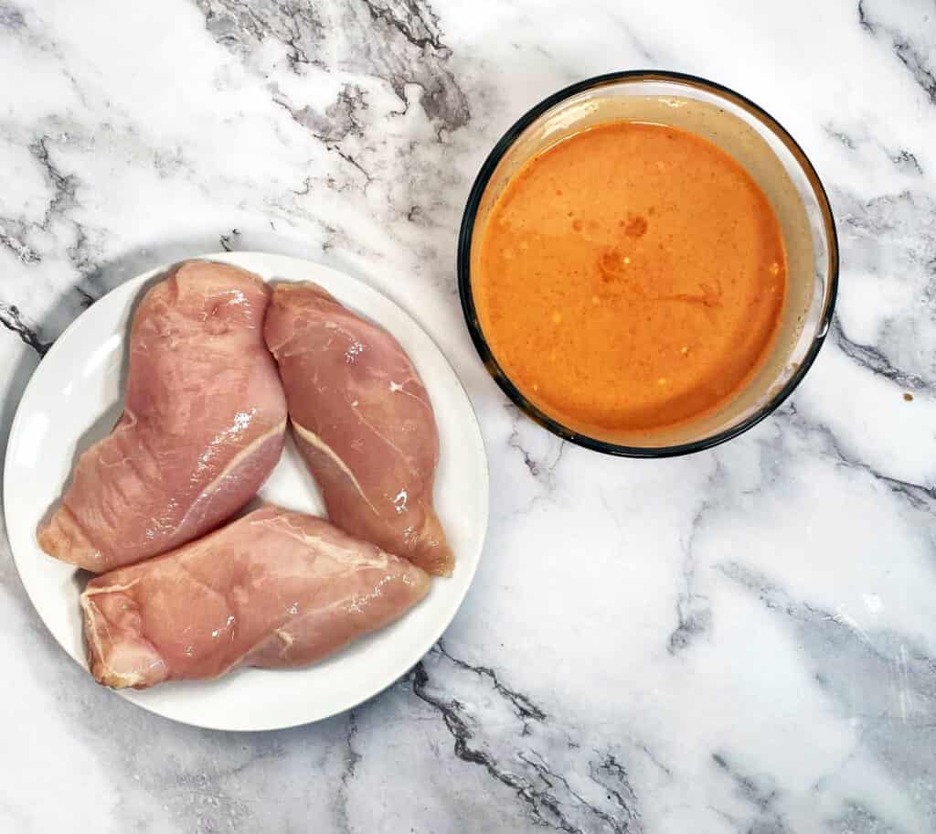 chicken breasts next to spicy bbq sauce