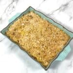 corn macaroni and cheese casserole in teal dish on marble background