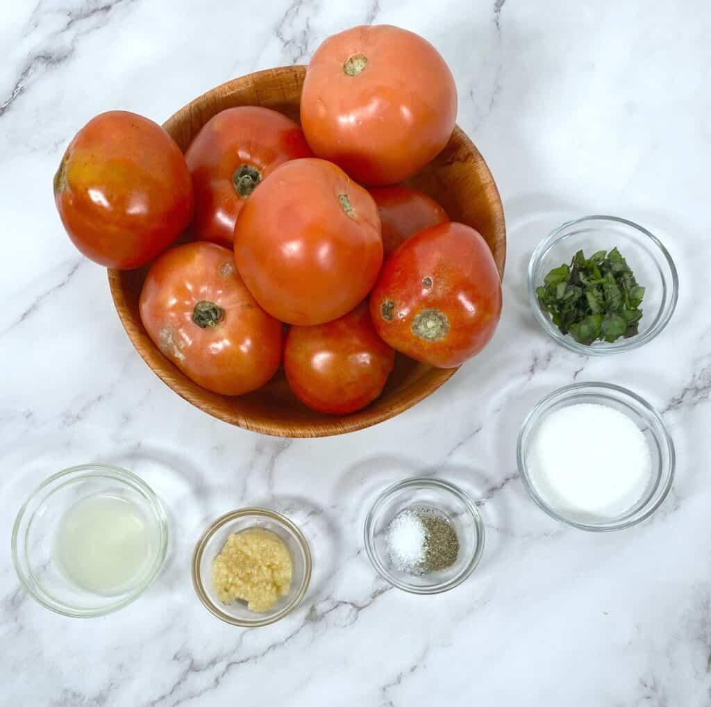 ingredients for homemade canned tomato sauce - tomatoes, garlic, parsley, basil, lemon juice, etc. 