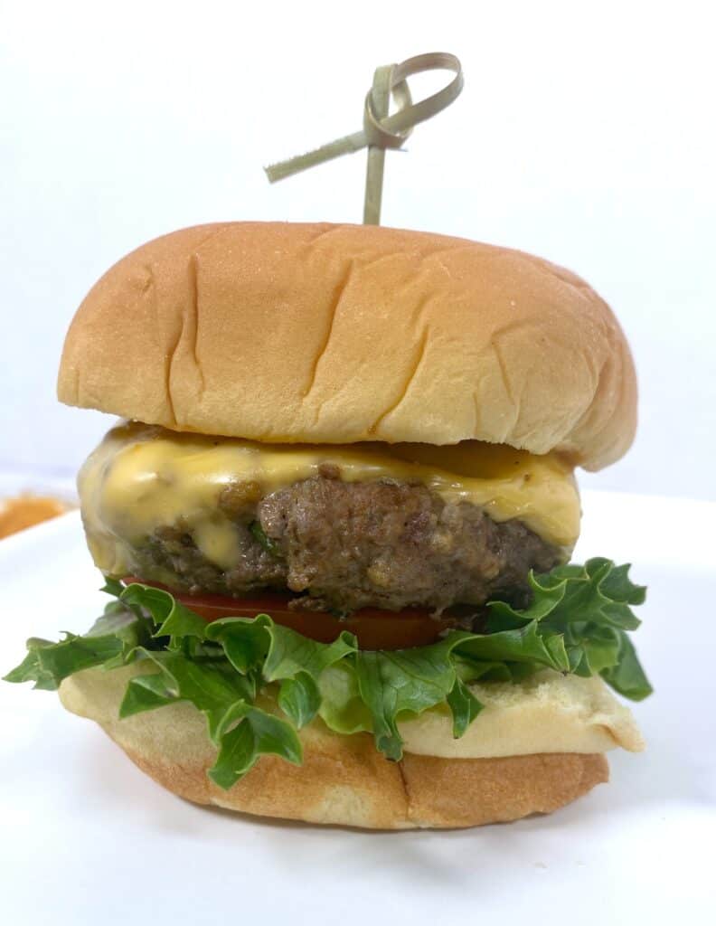 old bay burger topped with lettuce, tomato and cheese