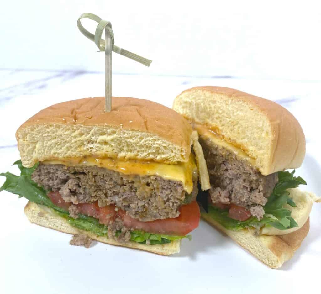 old bay burger with lettuce, tomato and cheese, sliced in half 