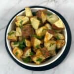 parmesan parsley roasted potatoes in white bowl