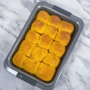 sweet potato dinner rolls in baking dish on marble