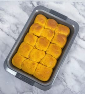 sweet potato dinner rolls, baked, in a 9x13 baking dish on a marble background