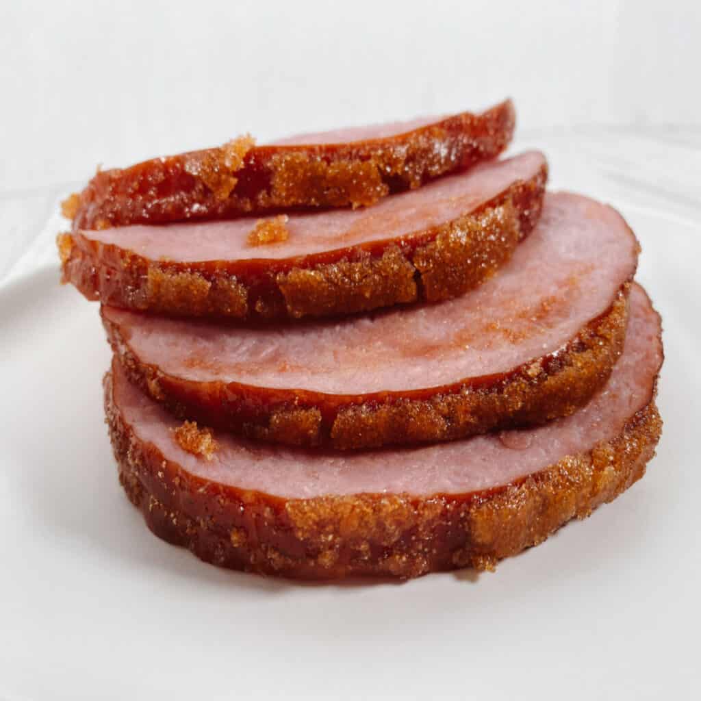 Layered stack of brown sugar mountain dew ham on a white plate