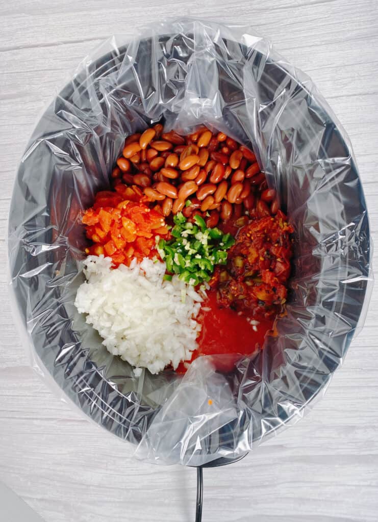 ingredients for crock pot chili and beans in a slow cooker 