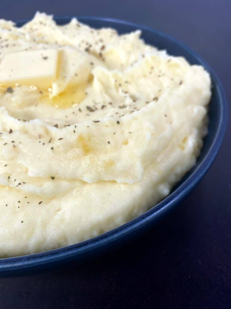 bowl of perfect creamy mashed potatoes with a pat of butter melting on top