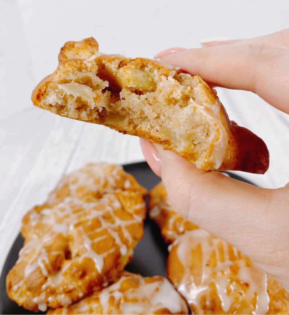 Air Fryer apple fritter with a bite taken out to show the pieces of apple in the fritter