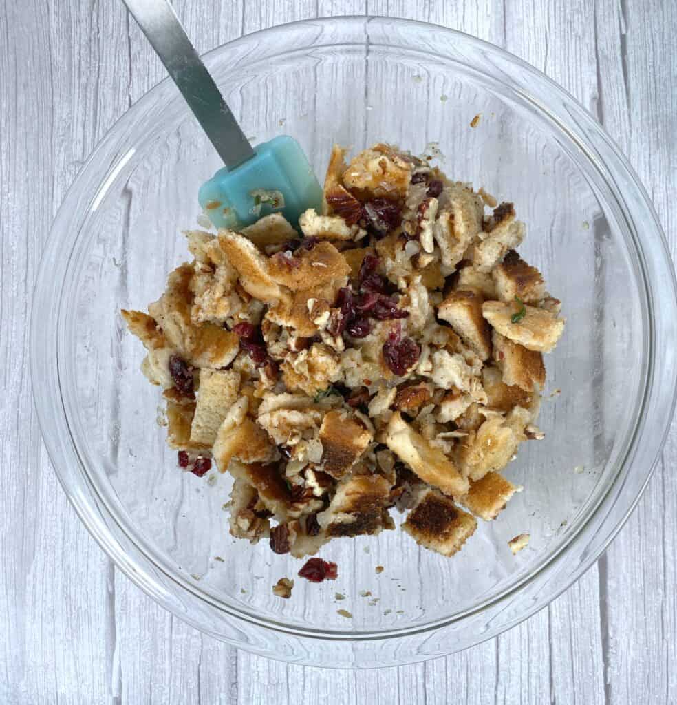 ingredients for cranberry pecan stuffing all mixed together in a bowl 