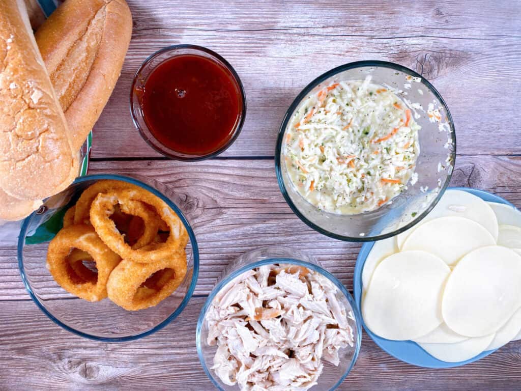 Ingredients for turkey slub sandwich – shredded turkey, barbecue sauce, provolone cheese, coleslaw, onion rings and sub rolls. 