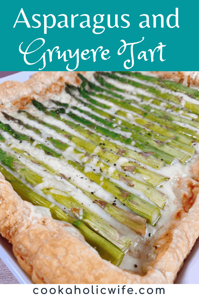 Close up image of asparagus and gruyere tart. Puff pastry is layered with a sauce and shredded gruyere cheese and topped with fresh asparagus spears, then baked to golden perfection. 