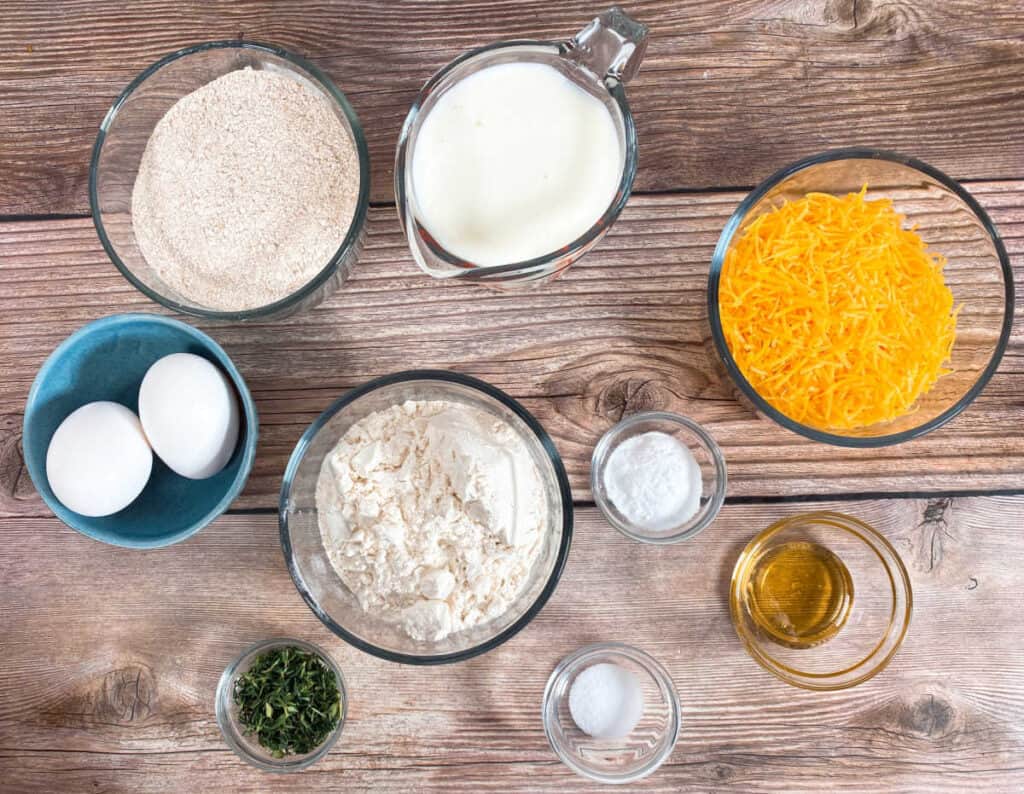 ingredients for cheddar thyme irish soda bread. All purpose flour, whole wheat flour, buttermilk, baking soda, honey, salt, eggs, shredded cheddar cheese and fresh thyme. 