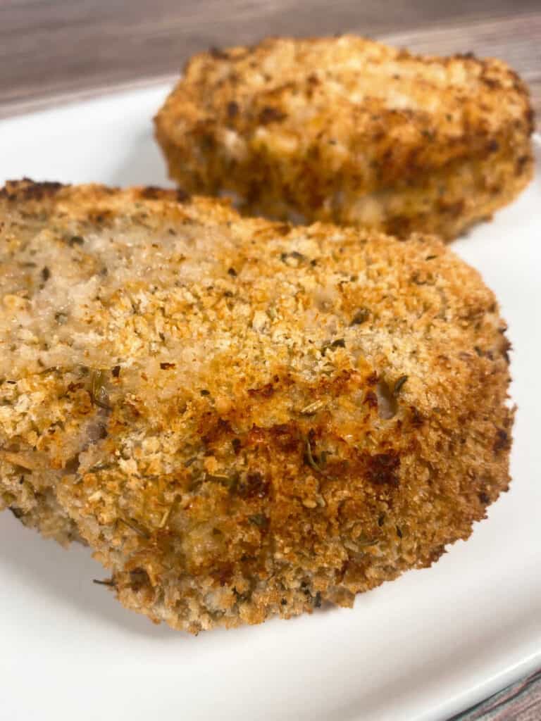 close up side image of the pork chop, showing the crispy coating made with Panko bread crumbs and Parmesan cheese.