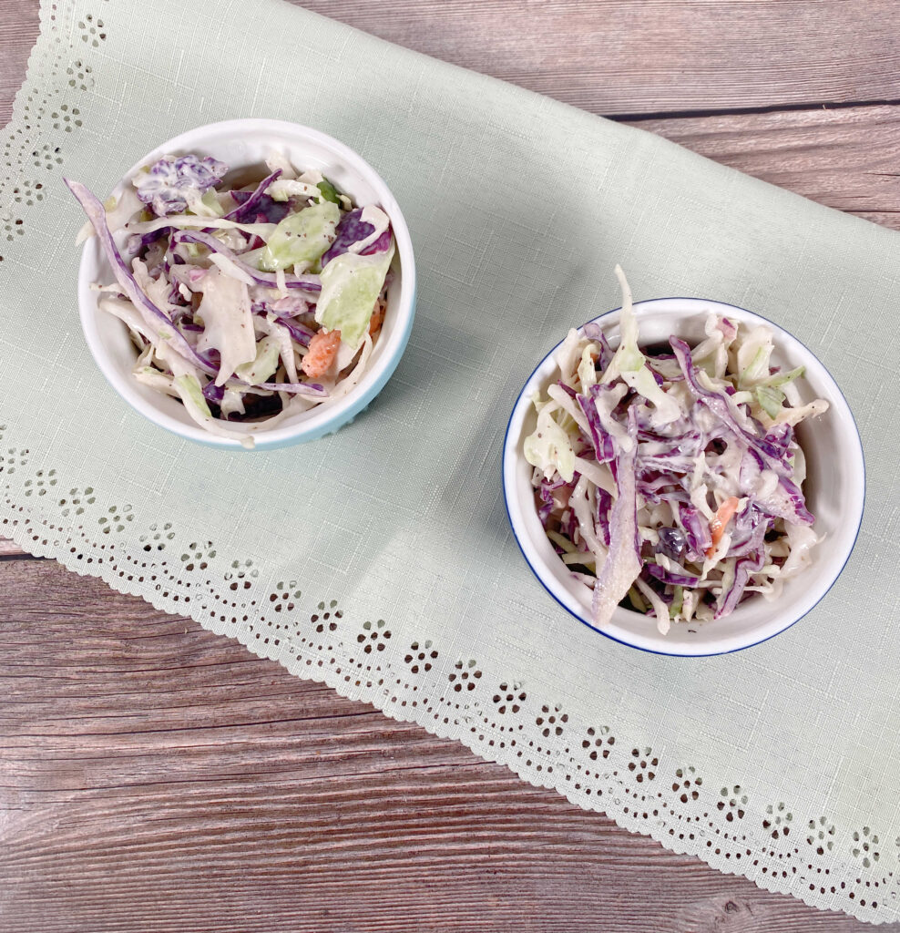 Prepared coleslaw sits in ramekins on a light green napkin, 