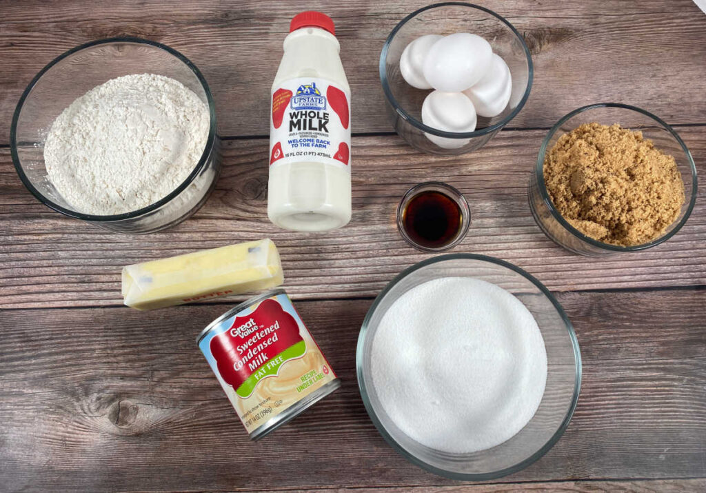 Ingredients for the cake sit on a wooden background. 