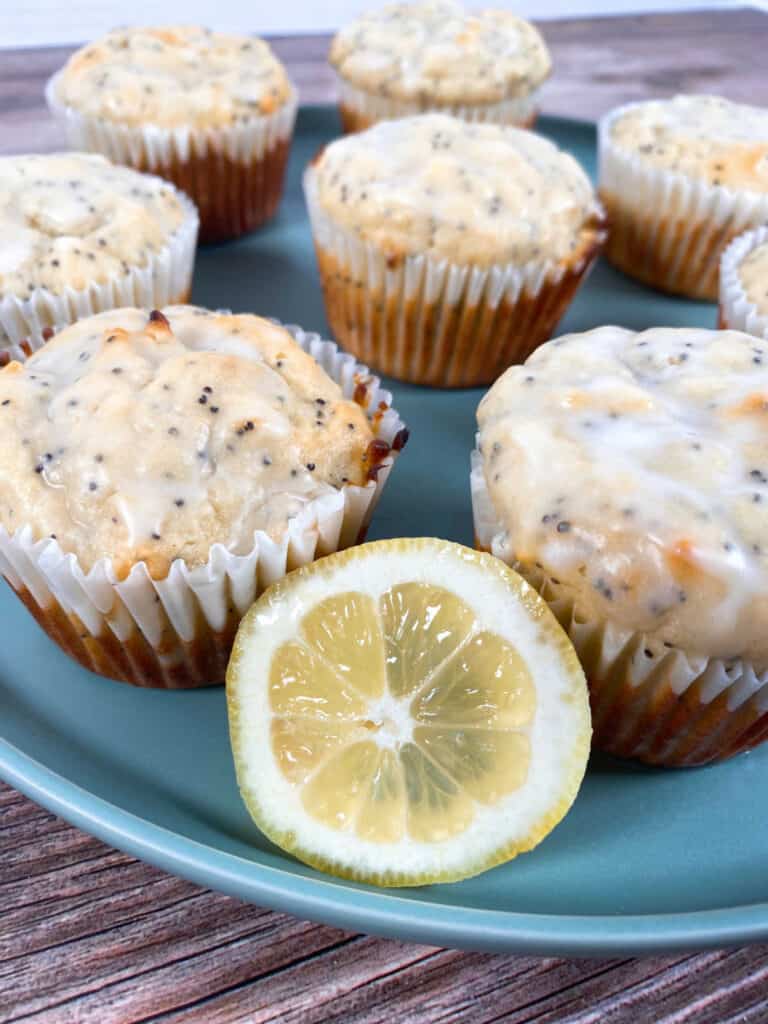 lemon poppy seed muffins sit on a light green plate.