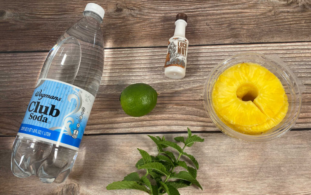 ingredients for the cocktail sit on a wooden background