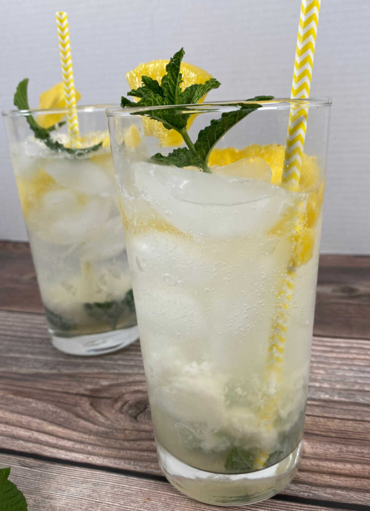 close up image of the cocktails, garnished with fresh pineapple, mint leaves and yellow straws