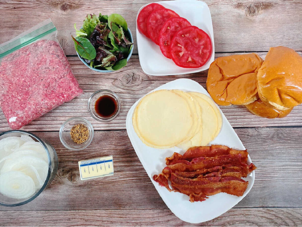 ingredients for the burger sit on a wooden background 