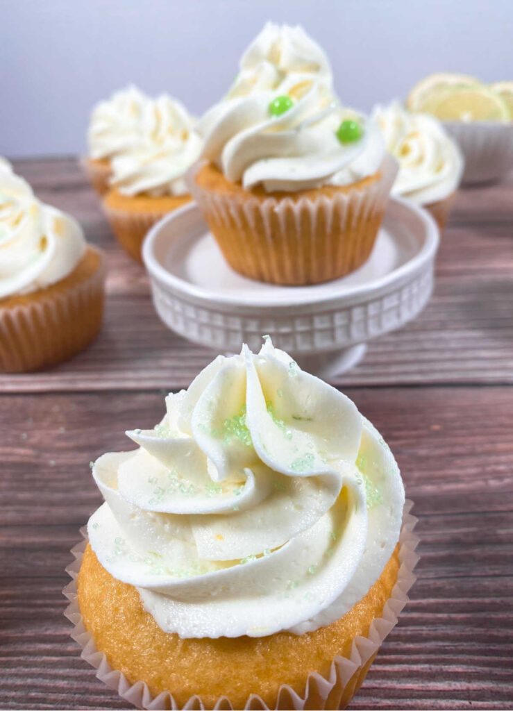 close up of cupcake decorated with green sanding sugar sits on a wooden background
