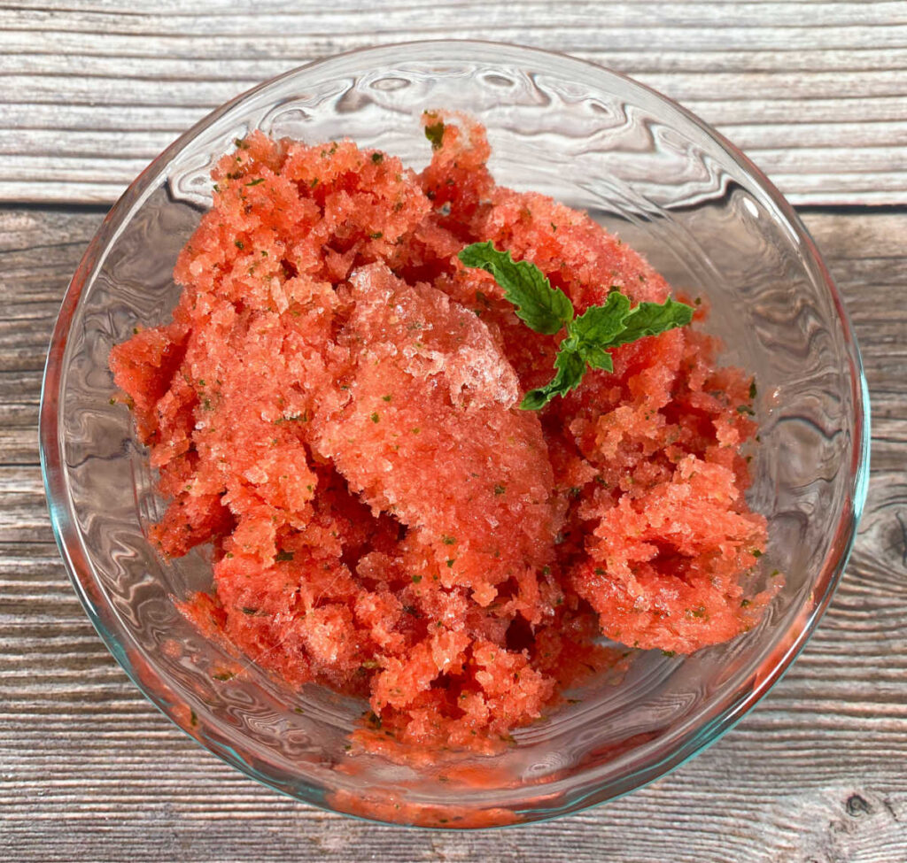 overhead image of the sorbet in a glass bowl, decorated with a sprig of mint 