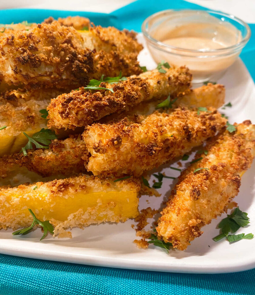 close up of the fries sitting on a white plate garnished with parsley 