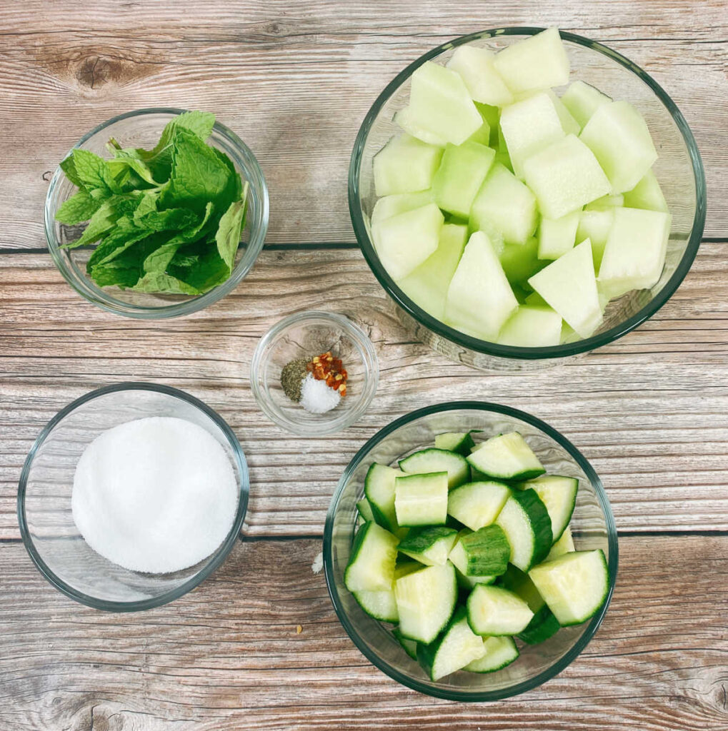 ingredients for the recipe sit in glass bowls on a wooden background