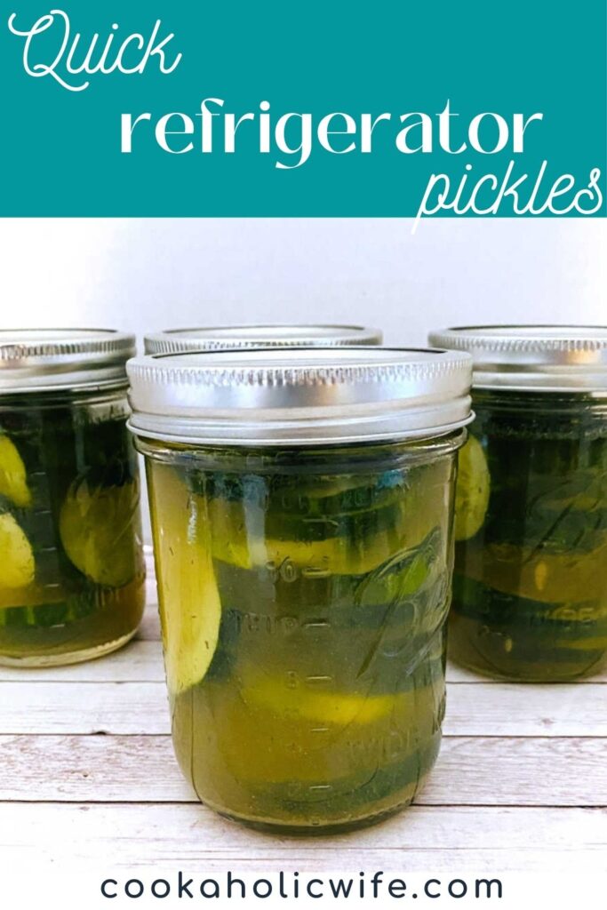 pickles sit in mason jars on a white wooden background. 