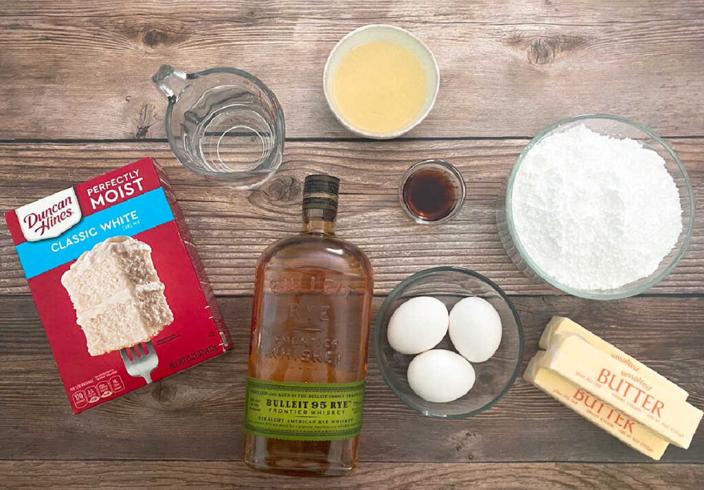 ingredients for cupcakes sit in glass bowls on a wooden background. 