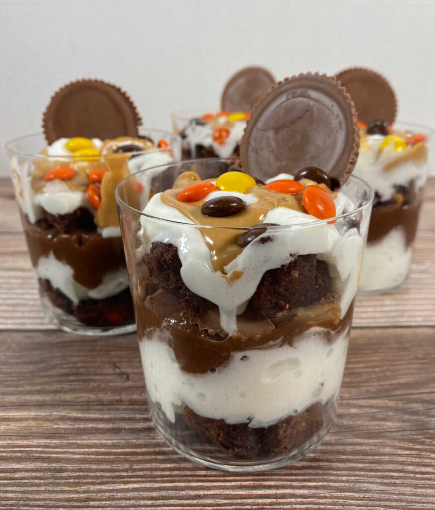 a trifle sits in the forefront showing off the layers of chocolate and peanut butter. 