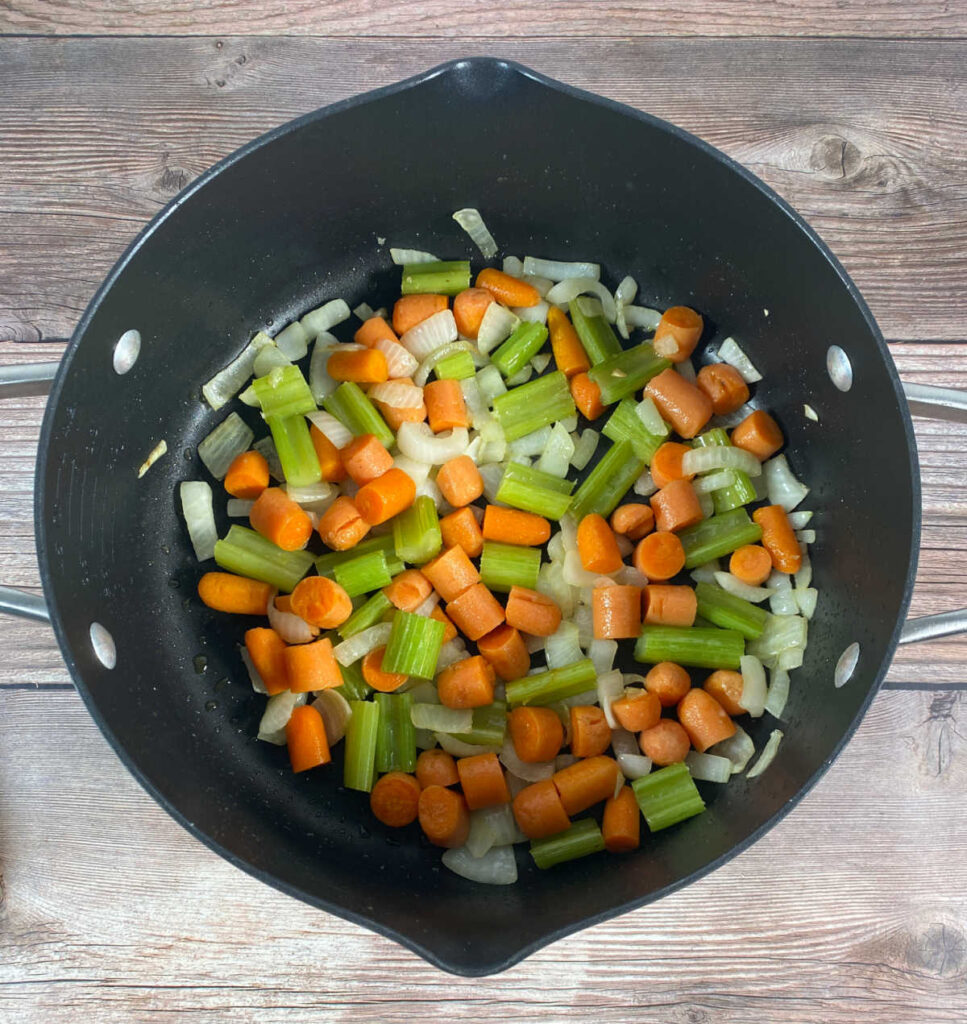 Process shot - stock pot full of sauteed carrots, onion and celery. 