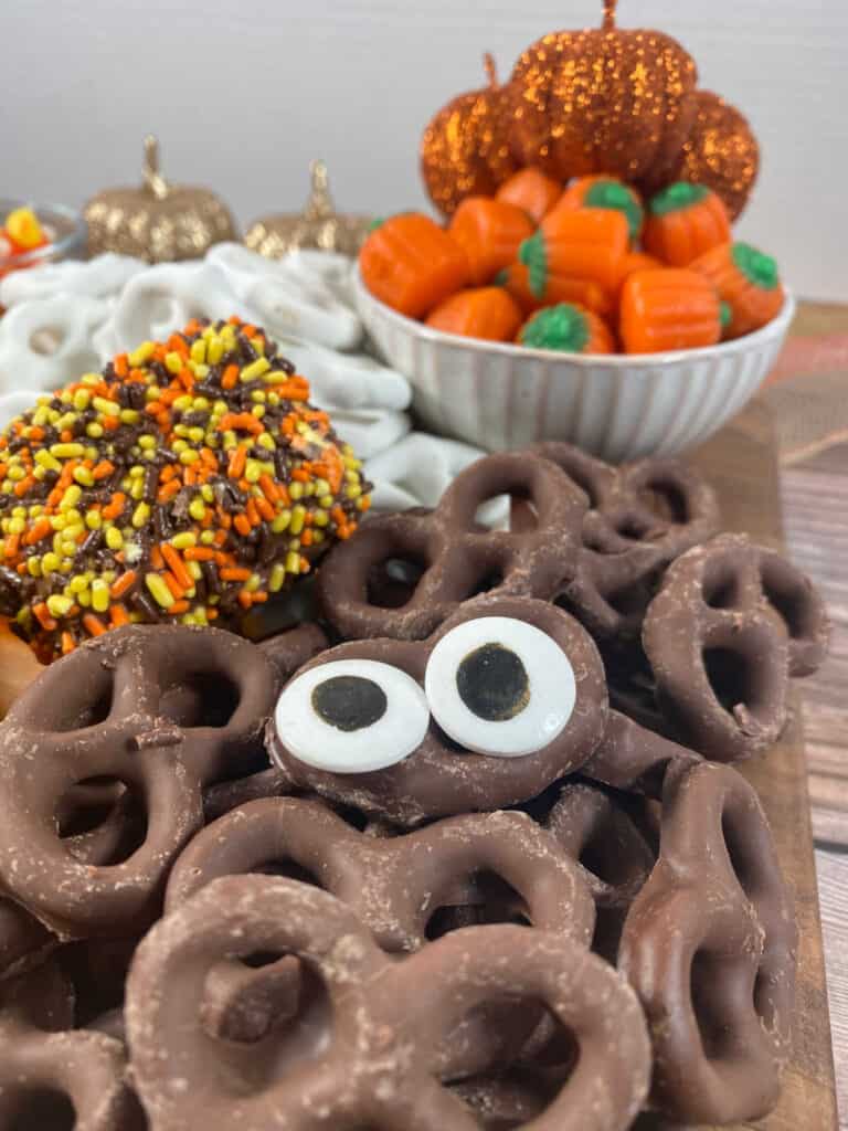 Close up image of candy eyeballs on chocolate covered pretzels.