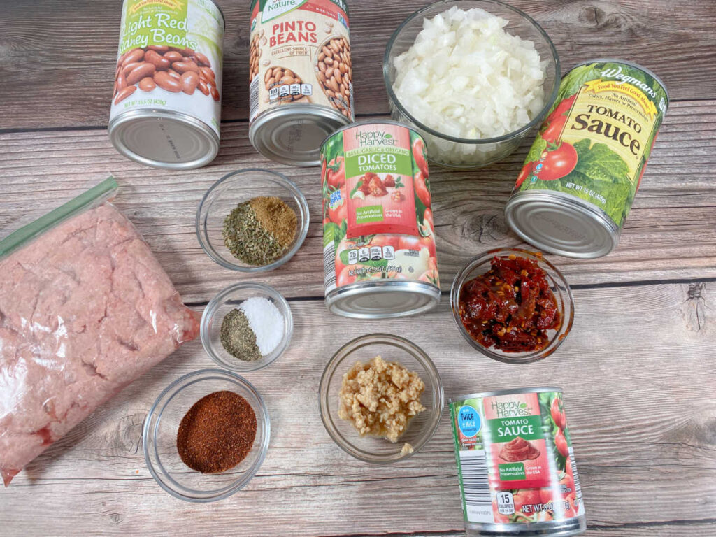 ingredients for the recipe sit in glass jars and cans on a wooden background 