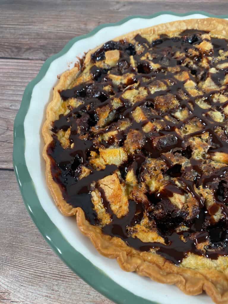 close up image of the cooked pie in the pie plate, showing the melted cookies inside and the crispy pie crust. 