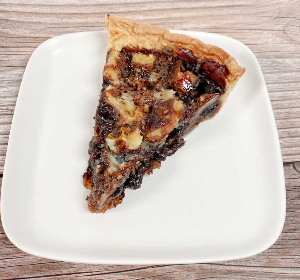 Overhead image of a slice of pie on a square white plate. 