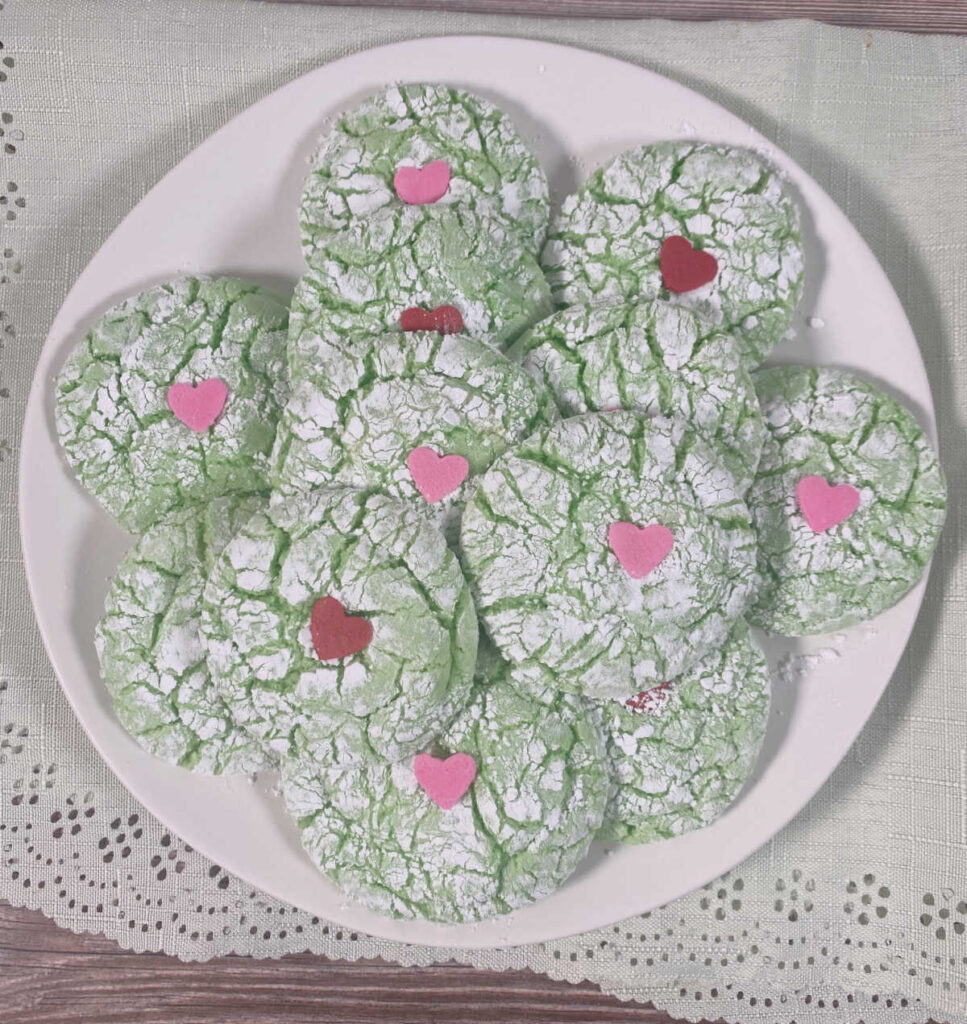 Round white plate of cookies sits on a light green napkin. 