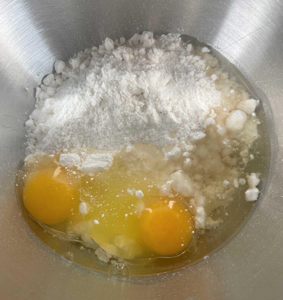 Process shot - cake batter, eggs and oil are in a mixing bowl. 