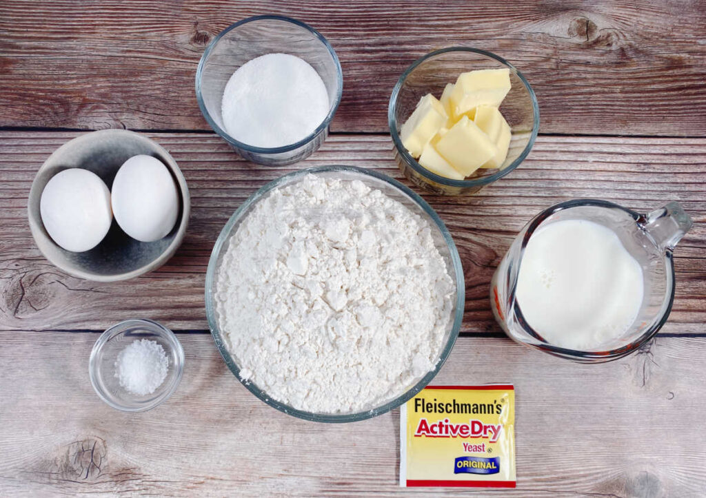 ingredients for the dinner rolls sit on a wooden background. 