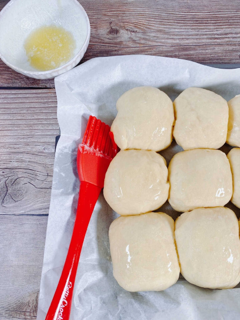 process shot - dough rolls brushed with butter, waiting to be baked. 