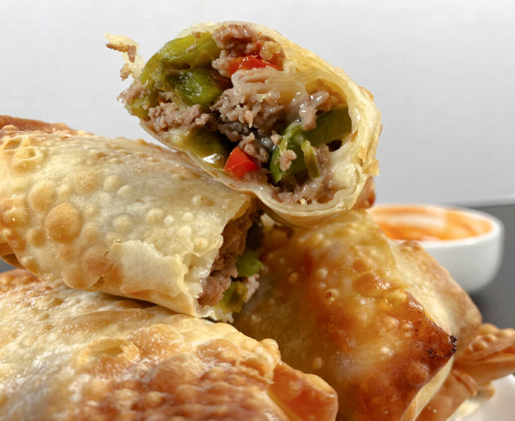 Close up image of a halved egg roll showing the filling. 
