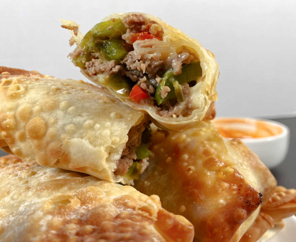 Close up image of a halved egg roll showing the filling.