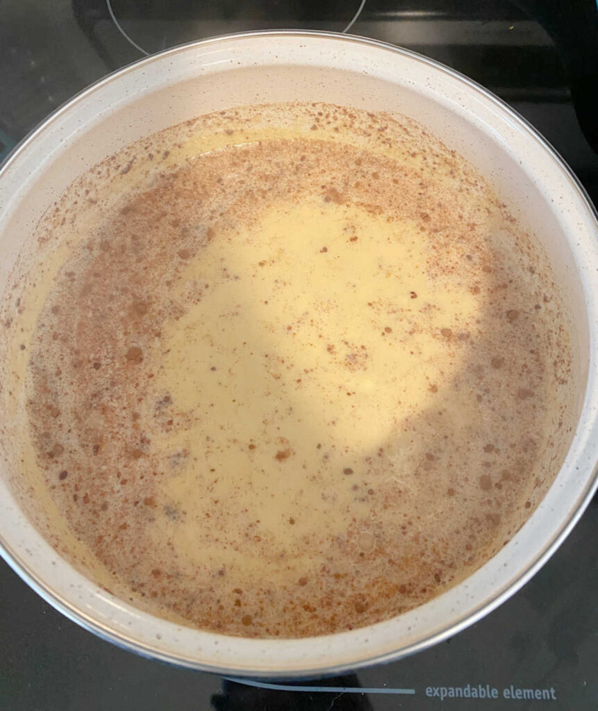 Process shot - overhead image of rice pudding cooking, once rice, cinnamon and salt have been stirred in. 