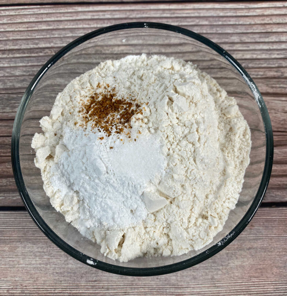 Process shot - dry ingredients are mixed together in a glass bowl. 