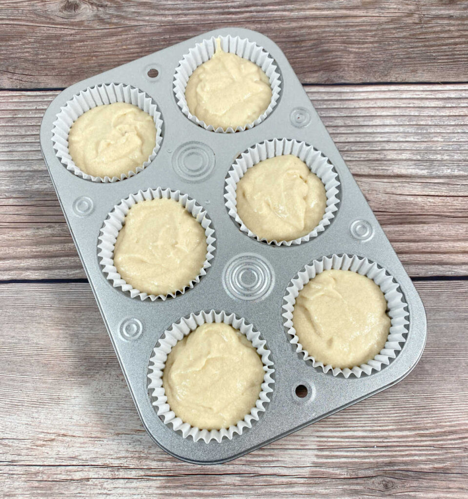 Process shot - cupcake batter is divided into cupcake pan waiting to be baked. 